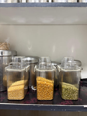 Clear containers with different types of grains on a metallic surface