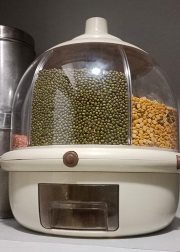 White pet food dispenser with transparent lid on a white surface.