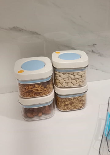 Three stacked food storage containers with labels on a white surface.